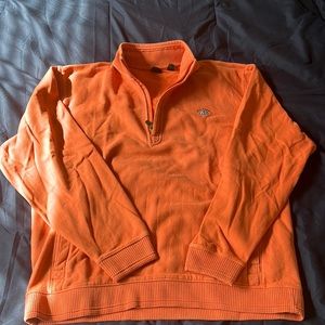 Orange quarter zip with Mackinaw City insignia.